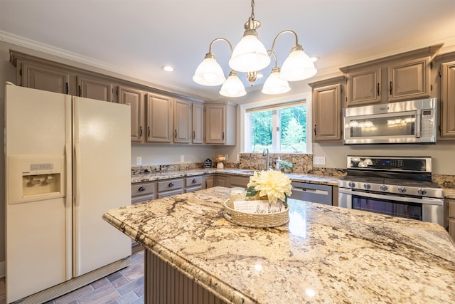 146 Old Sandown Rd, Chester, NH 03036 - kitchen with stainless steel appliances, a chandelier, light stone countertops, pendant lighting, and crown molding