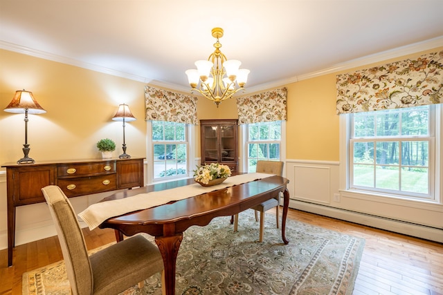 146 Old Sandown Rd, Chester, NH 03036 - dining room with a chandelier, a baseboard radiator, light wood finished floors, a wainscoted wall, and crown molding