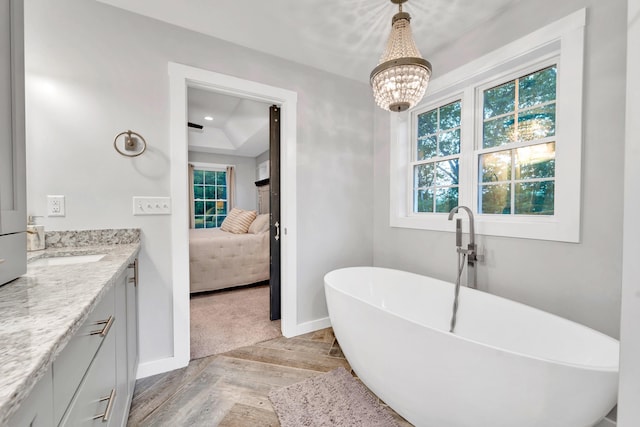 27 Westbrook Dr, New Ipswich, NH 03071 - ensuite bathroom featuring vanity, a freestanding bath, healthy amount of natural light, a raised ceiling, and recessed lighting