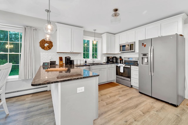 27 Westbrook Dr, New Ipswich, NH 03071 - kitchen featuring appliances with stainless steel finishes, a peninsula, light wood-style floors, and healthy amount of natural light