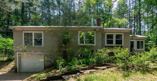 70 Tabor Cir, Albany, NH 03818 - view of front of house featuring an attached garage, a chimney, a metal roof, and driveway