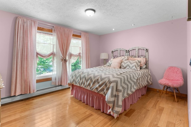 70 Tabor Cir, Albany, NH 03818 - bedroom featuring baseboard heating, light wood-style flooring, and a textured ceiling