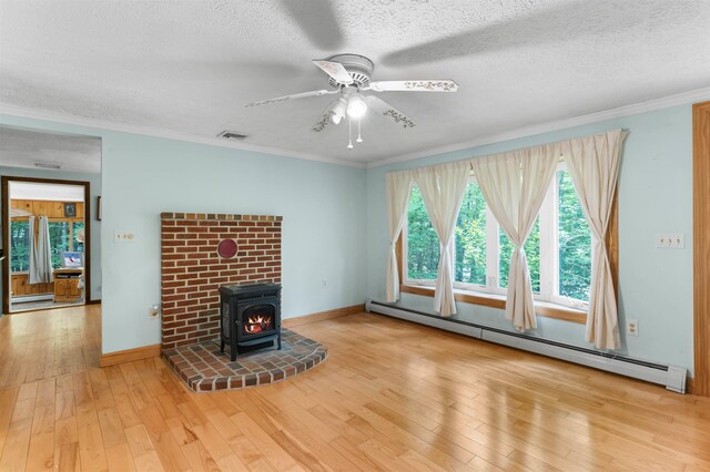 70 Tabor Cir, Albany, NH 03818 - unfurnished living room featuring a baseboard radiator, a wood stove, hardwood / wood-style flooring, ceiling fan, and a textured ceiling