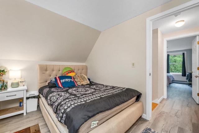 24 Meredith Center Rd, Meredith, NH 03253 - bedroom featuring light wood finished floors, vaulted ceiling, and a baseboard radiator