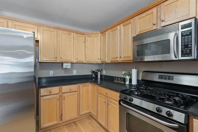 67 Pearl St Unit 8, Essex Junction, VT 05452 - kitchen featuring stainless steel appliances, dark countertops, and light brown cabinetry
