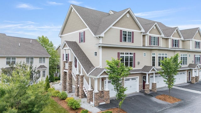 11 Manor Dr Unit D, Hooksett, NH 03106 - multi unit property with driveway, an attached garage, stone siding, roof with shingles, and a residential view