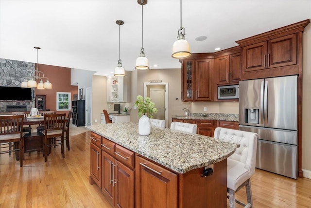 74 Settlers Ct, Bedford, NH 03110 - kitchen with appliances with stainless steel finishes, light wood-style floors, light stone counters, a center island, and glass insert cabinets