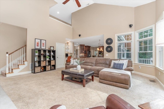 74 Settlers Ct, Bedford, NH 03110 - carpeted living room with high vaulted ceiling, ceiling fan, stairway, and a chandelier