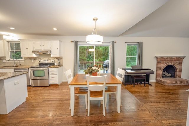 26 Harvard Ln, Bedford, NH 03110 - dining area with recessed lighting, light wood finished floors, a brick fireplace, and lofted ceiling