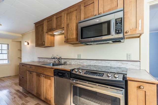 11 Bridge St, Kittery, ME 03904 - kitchen with stainless steel appliances, light wood finished floors, light countertops, brown cabinetry, and ornamental molding