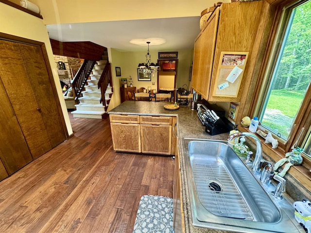 851 German Flats Rd, Fayston, VT 05673 - kitchen featuring a peninsula, dark wood-style flooring, brown cabinets, a chandelier, and decorative light fixtures