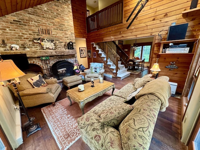 851 German Flats Rd, Fayston, VT 05673 - living room with wooden walls, wood-type flooring, high vaulted ceiling, stairway, and a fireplace