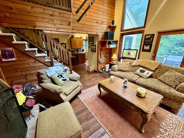 851 German Flats Rd, Fayston, VT 05673 - living room featuring a towering ceiling, healthy amount of natural light, stairs, hardwood / wood-style flooring, and wood walls