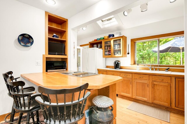 175 Middle Rd, Portsmouth, NH 03801 - kitchen featuring freestanding refrigerator, open shelves, electric stovetop, a kitchen breakfast bar, and glass insert cabinets