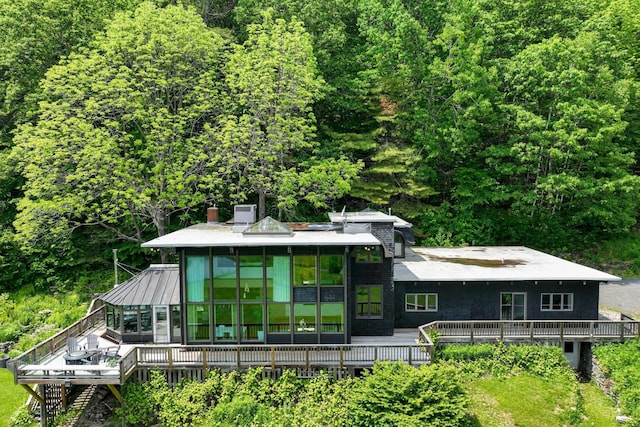 465 Pennell Rd, Chester, VT 05143 - back of property featuring a deck, a forest view, a chimney, and a sunroom