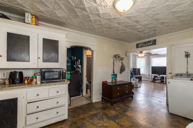 43AB River St, Rochester, NH 03867 - kitchen featuring stainless steel microwave, arched walkways, washer / dryer, ceiling fan, and white cabinetry