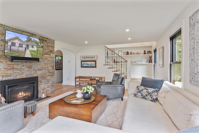 1549 Hinesburg Rd, South Burlington, VT 05403 - living area with stairs, wood finished floors, arched walkways, a stone fireplace, and recessed lighting