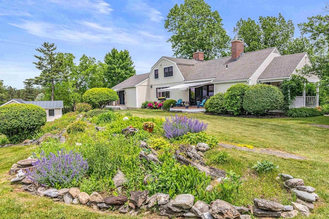 1549 Hinesburg Rd, South Burlington, VT 05403 - view of front facade with a chimney, a front yard, roof with shingles, and a patio