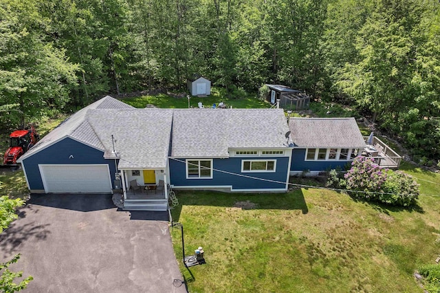 30 Dillon Dr E E, Unit East, Strafford, NH 03884 - view of front of home with asphalt driveway, a front yard, a shed, an attached garage, and a forest view