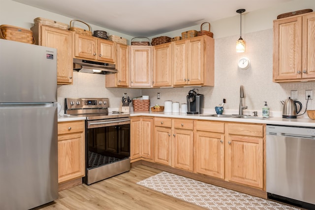 118 Secretariat Way Unit 115, Rochester, NH 03867 - kitchen with appliances with stainless steel finishes, under cabinet range hood, light brown cabinetry, light countertops, and light wood-style floors
