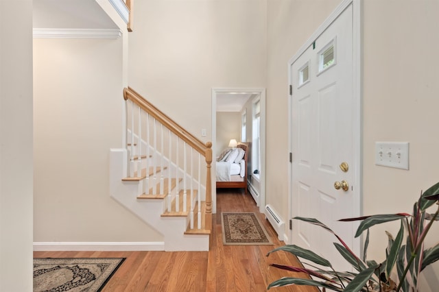 202 Cherry Valley Rd, Alton, NH 03810 - entrance foyer with a baseboard radiator, wood finished floors, stairway, ornamental molding, and a towering ceiling