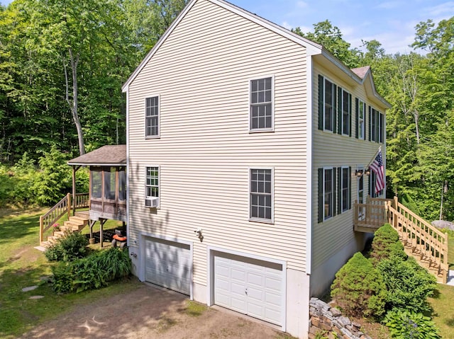 202 Cherry Valley Rd, Alton, NH 03810 - view of side of home with stairway, an attached garage, driveway, and a sunroom