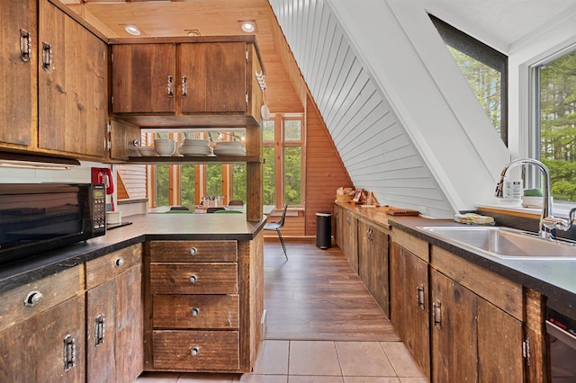 812 Airport Rd, Fayston, VT 05660 - kitchen with black microwave, wooden walls, dark countertops, dishwashing machine, and a peninsula