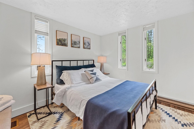 812 Airport Rd, Fayston, VT 05660 - bedroom featuring wood finished floors and a textured ceiling