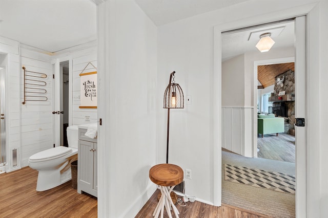 812 Airport Rd, Fayston, VT 05660 - bathroom featuring wood finished floors, a stone fireplace, and vanity