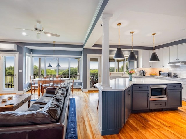 1411 Spear St, South Burlington, VT 05403 - kitchen with stainless steel microwave, a wall mounted air conditioner, light countertops, a ceiling fan, and light wood-type flooring