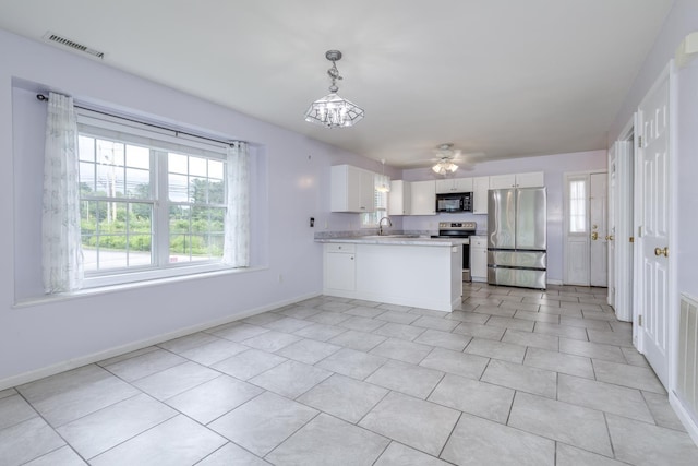 491 Mammoth Rd Unit 7, Londonderry, NH 03053 - kitchen featuring appliances with stainless steel finishes, light countertops, white cabinetry, a peninsula, and a chandelier