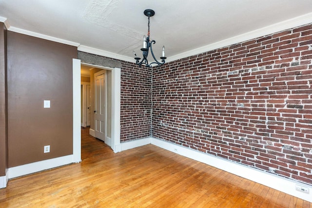 102 W Merrimack St Unit 1, Manchester, NH 03101 - unfurnished dining area with light wood-type flooring, crown molding, a chandelier, and brick wall