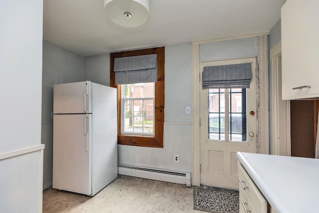 102 W Merrimack St Unit 1, Manchester, NH 03101 - kitchen with freestanding refrigerator, a baseboard radiator, white cabinetry, and light countertops