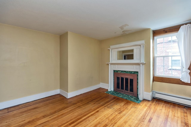 102 W Merrimack St Unit 1, Manchester, NH 03101 - unfurnished living room featuring baseboard heating, light wood finished floors, and a tile fireplace