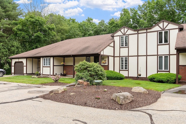 3 Chandler Dr, Atkinson, NH 03811 - tudor-style house featuring a garage, stucco siding, a front lawn, and a shingled roof