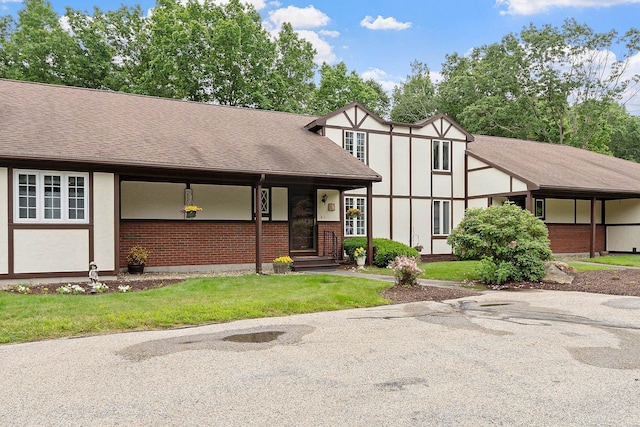3 Chandler Dr, Atkinson, NH 03811 - english style home featuring brick siding, a front yard, a shingled roof, and stucco siding