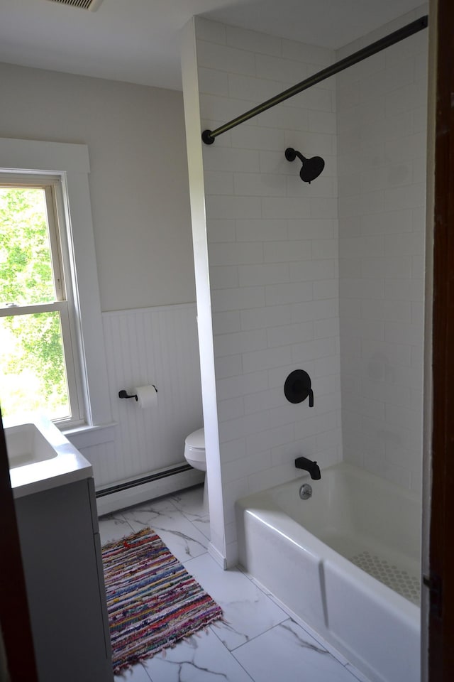 27 Randall St, Waterbury, VT 05676 - bathroom featuring a baseboard radiator, marble look tiles, a wainscoted wall, vanity, and shower / bathtub combination