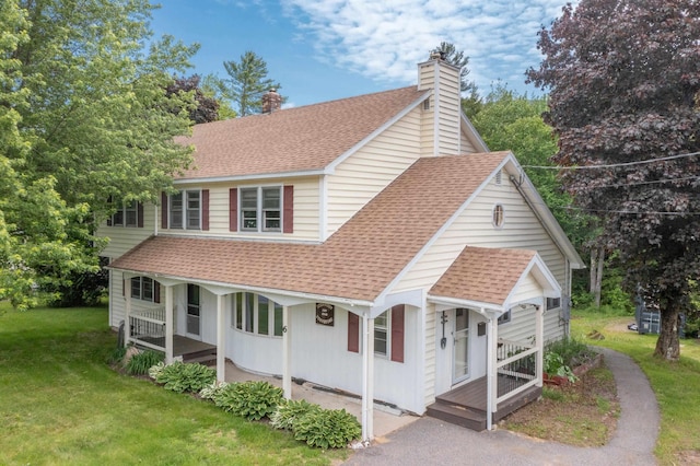 6 Goodbout Rd, Lincoln, NH 03251 - view of front of home featuring covered porch, a shingled roof, a front yard, and a chimney