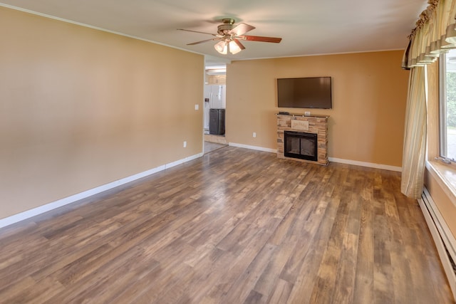 6 Goodbout Rd, Lincoln, NH 03251 - unfurnished living room featuring a baseboard heating unit, a ceiling fan, a fireplace, wood finished floors, and ornamental molding