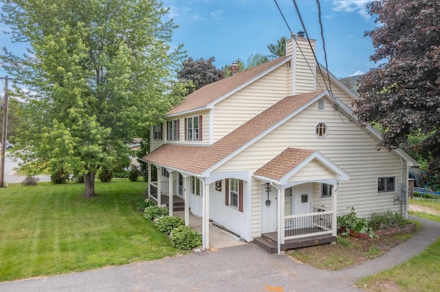6 Goodbout Rd, Lincoln, NH 03251 - view of front of house with a porch, a shingled roof, a front yard, and a chimney