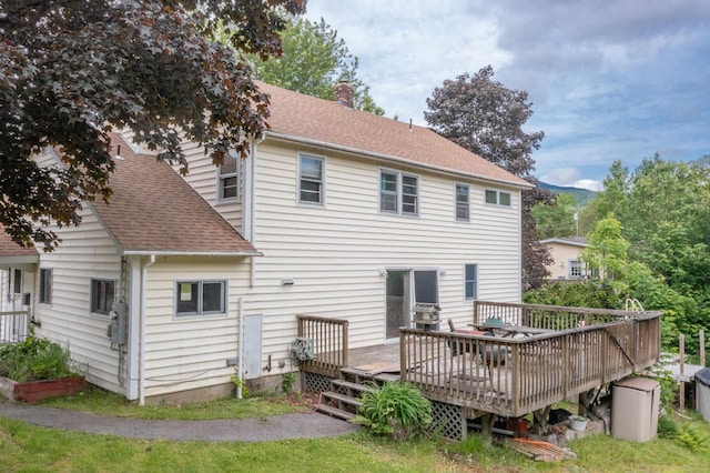 6 Goodbout Rd, Lincoln, NH 03251 - back of property with a wooden deck, a shingled roof, and a chimney
