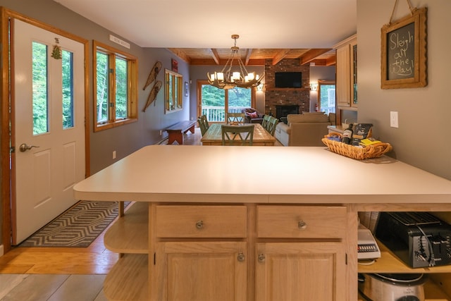26 Country Xing, Ludlow, VT 05149 - kitchen featuring light countertops, a chandelier, open floor plan, a brick fireplace, and beam ceiling