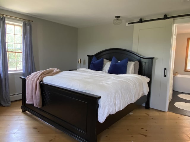 69 Emerson Hill Rd, New Ipswich, NH 03071 - bedroom featuring light wood-type flooring, a baseboard radiator, and a barn door