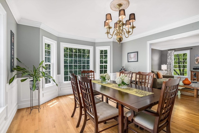 11 Mcafee Farm Rd, Bedford, NH 03110 - dining area with light wood-style flooring, a chandelier, crown molding, and a wainscoted wall