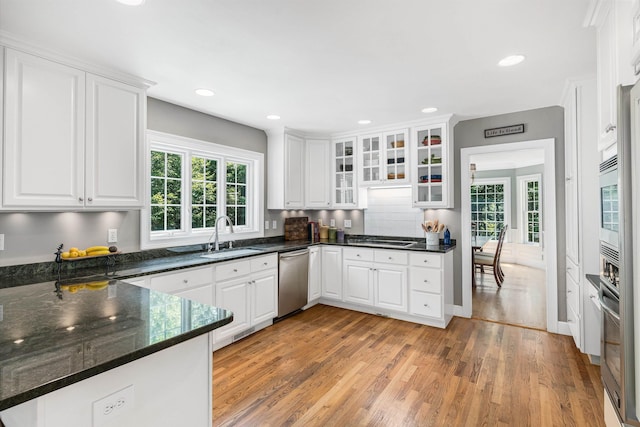 11 Mcafee Farm Rd, Bedford, NH 03110 - kitchen with appliances with stainless steel finishes, light wood-style flooring, white cabinets, glass insert cabinets, and recessed lighting
