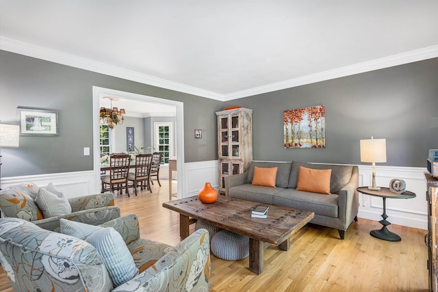 11 Mcafee Farm Rd, Bedford, NH 03110 - living area featuring crown molding, a chandelier, wood finished floors, and a wainscoted wall