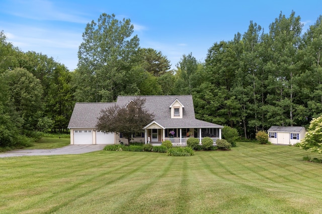 204 Mary Dr, Richmond, VT 05477 - view of front of property featuring a porch, asphalt driveway, an attached garage, a front lawn, and an outbuilding