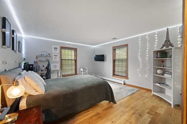 2 Ridgewood Dr, Kingston, NH 03848 - bedroom featuring a baseboard heating unit and light wood-style flooring
