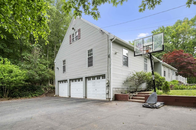 2 Ridgewood Dr, Kingston, NH 03848 - view of side of property featuring asphalt driveway and a garage