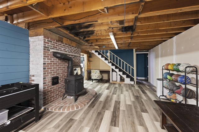 2 Ridgewood Dr, Kingston, NH 03848 - finished basement featuring a wood stove, stairs, and wood finished floors